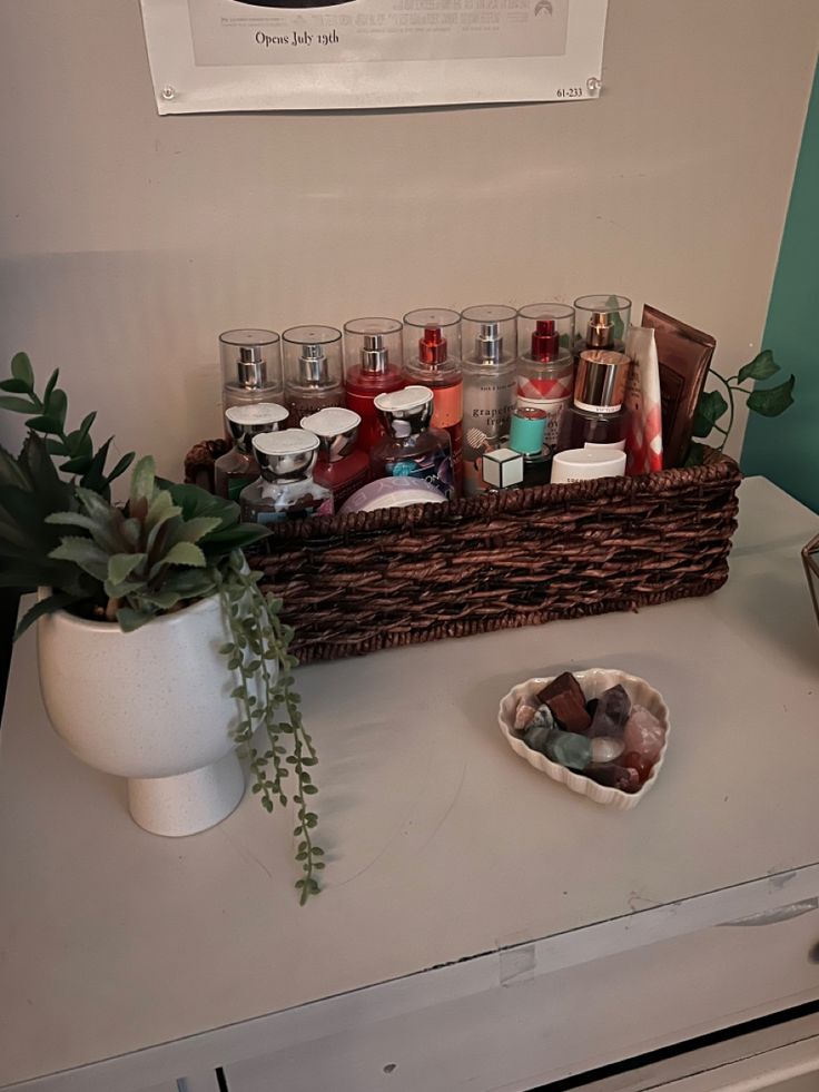 a basket filled with lots of different items on top of a white counter next to a potted plant