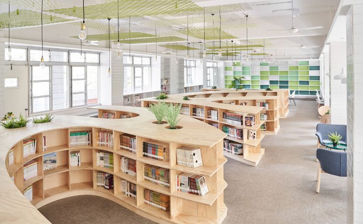 an empty library with many bookshelves and plants on the shelves in front of them