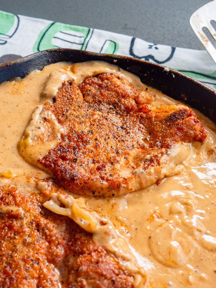 a skillet filled with meat covered in gravy