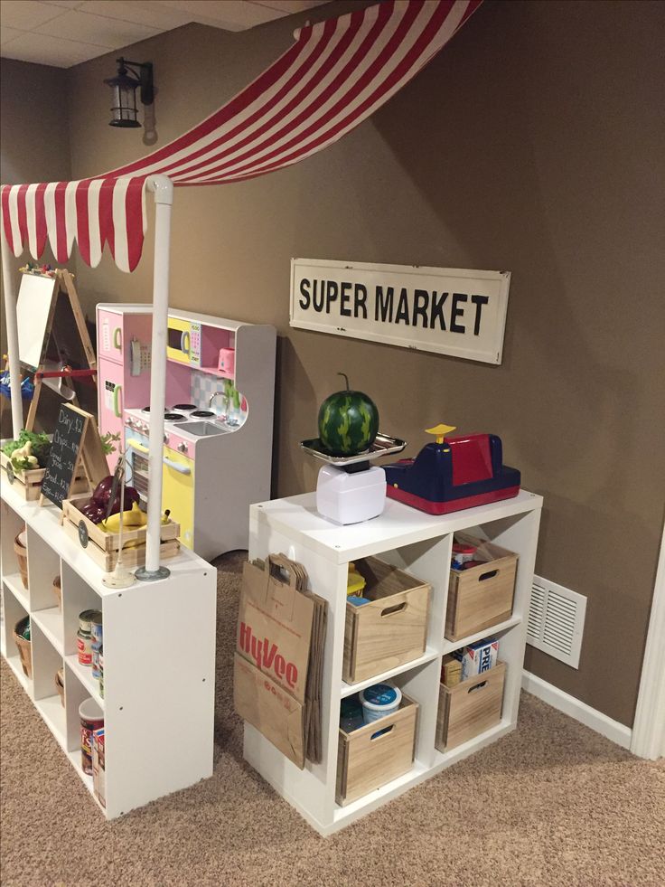 a room with shelves, bins and boxes on the floor in front of a sign that reads super market