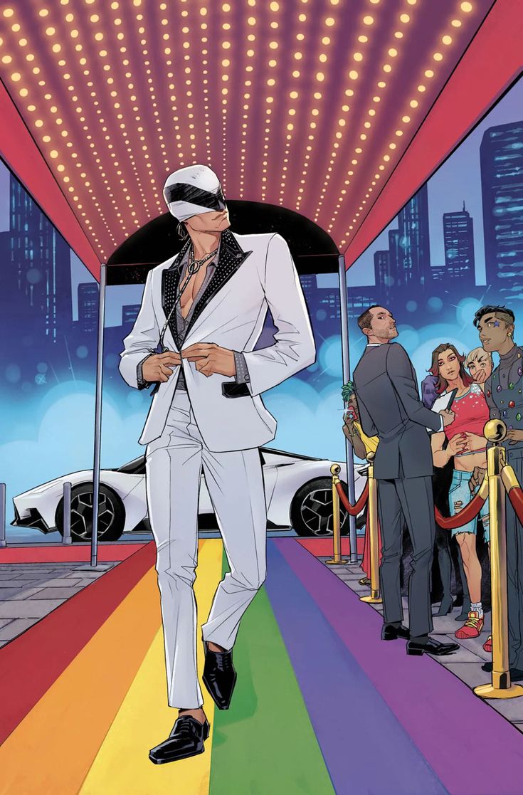 a man in a white suit and tie walking down a rainbow colored carpeted street