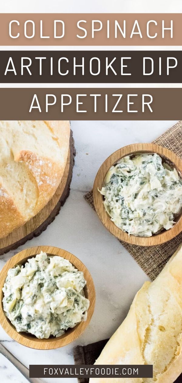 two wooden spoons filled with spinach artichoke dip appetizer next to bread