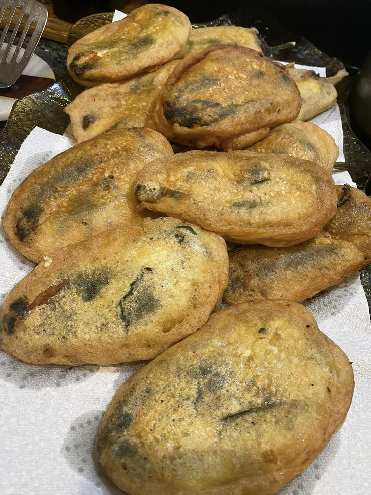 a pile of chocolate chip cookies sitting on top of a paper towel next to a fork