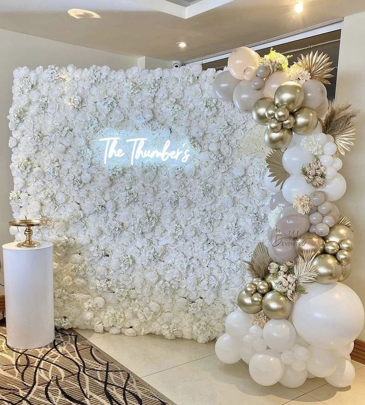 a white and gold wedding backdrop with flowers, balloons and the words the tenders on it