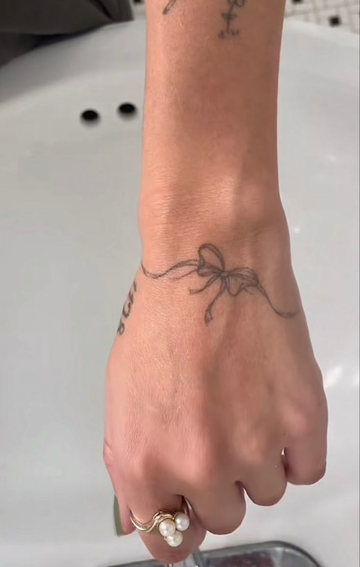 a person with a tattoo on their left arm and hand holding something in front of them