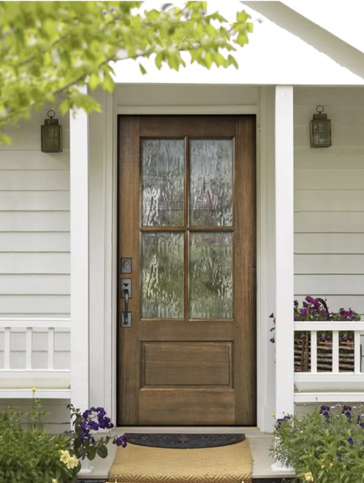 the front door of a house with flowers and plants