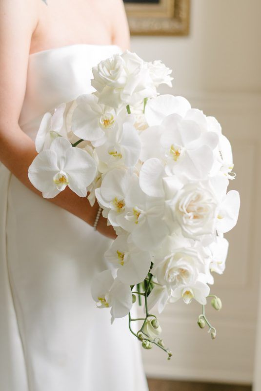 a bride holding a bouquet of white flowers