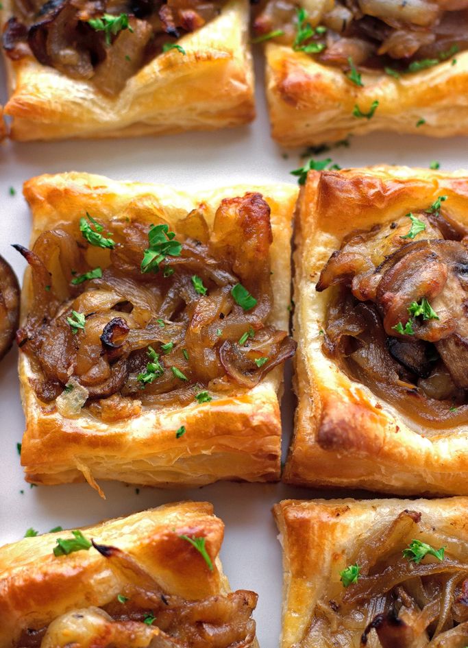 several square pastries with mushrooms and parsley on top