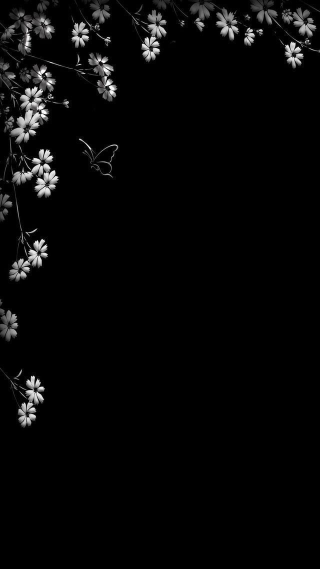 black and white photograph of flowers with butterflies flying around the corner on a dark background