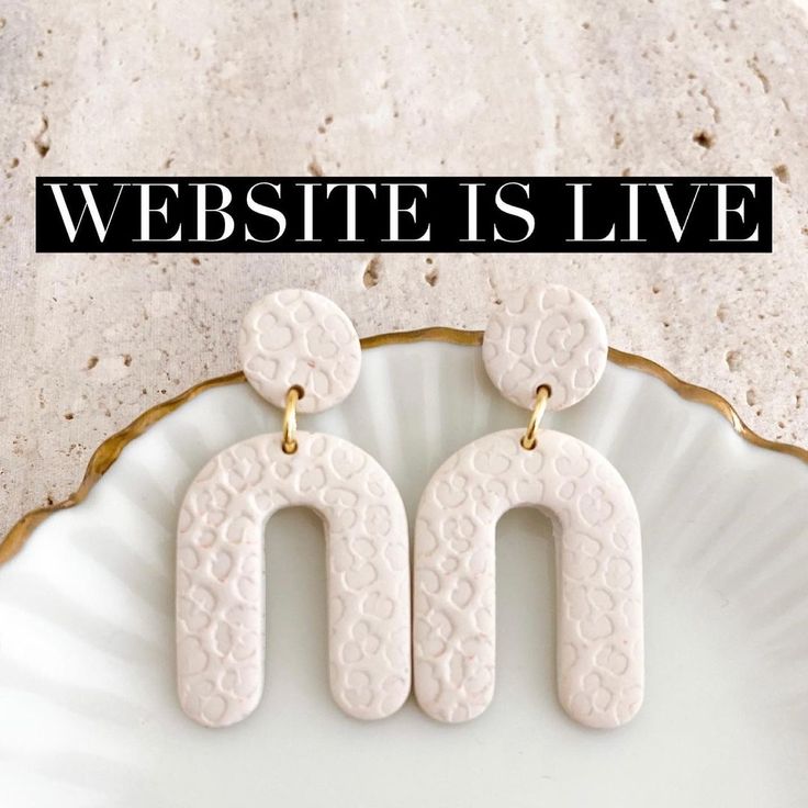 the words website is live are displayed in front of a white plate with gold accents