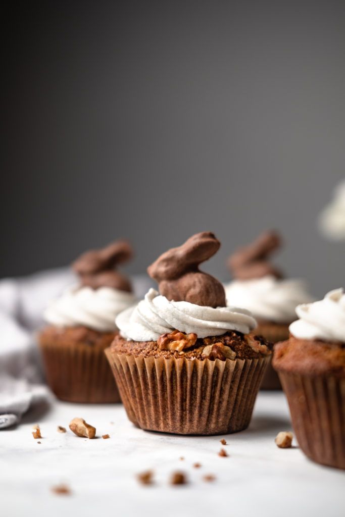 several cupcakes with white frosting and chocolate bunny ears