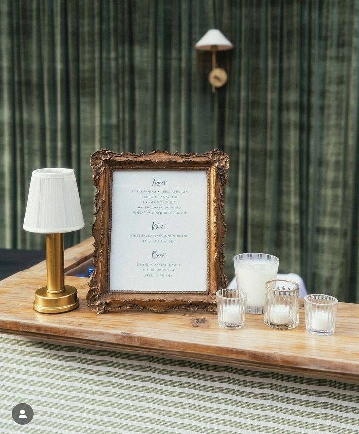 a wooden table topped with candles and a framed sign