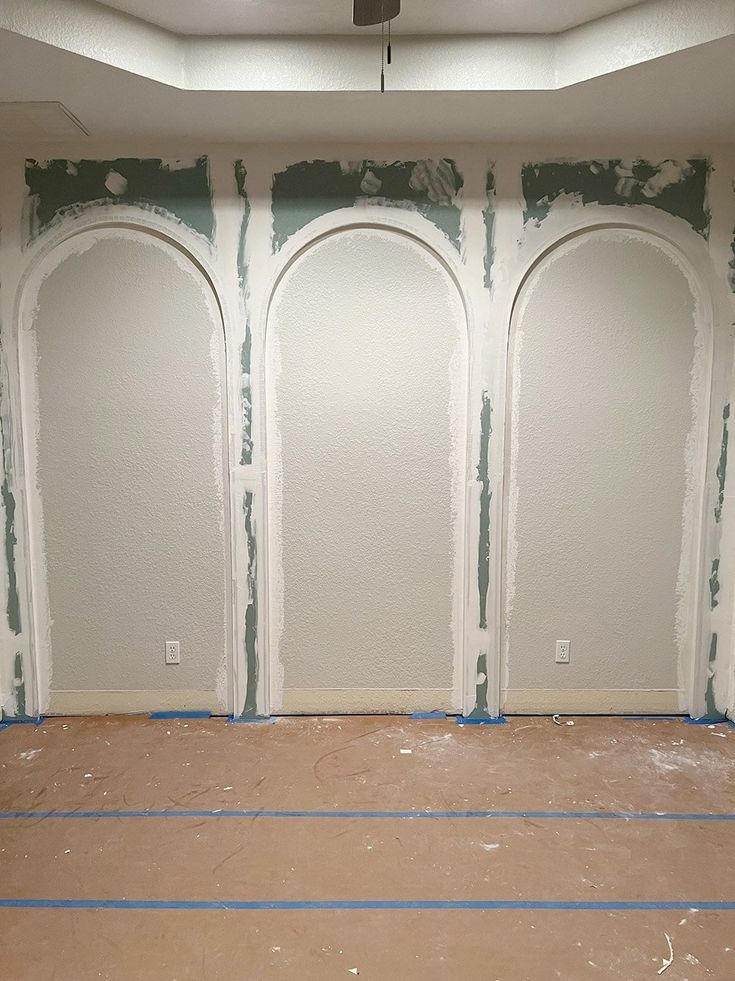 an empty room with three arches painted on the wall