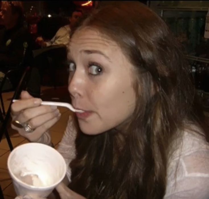 a woman is eating from a paper cup