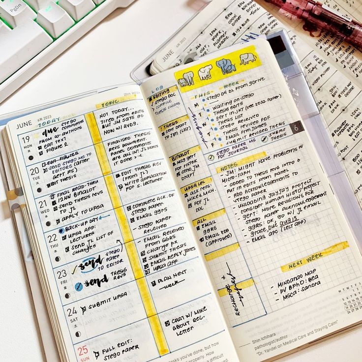 an open planner sitting on top of a desk next to a keyboard