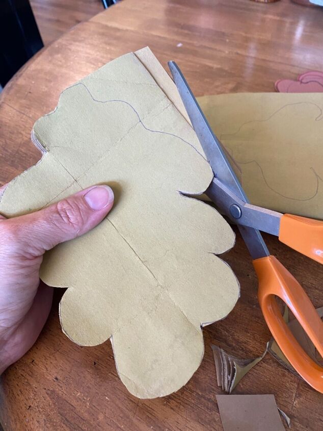 a person cutting out paper on top of a wooden table