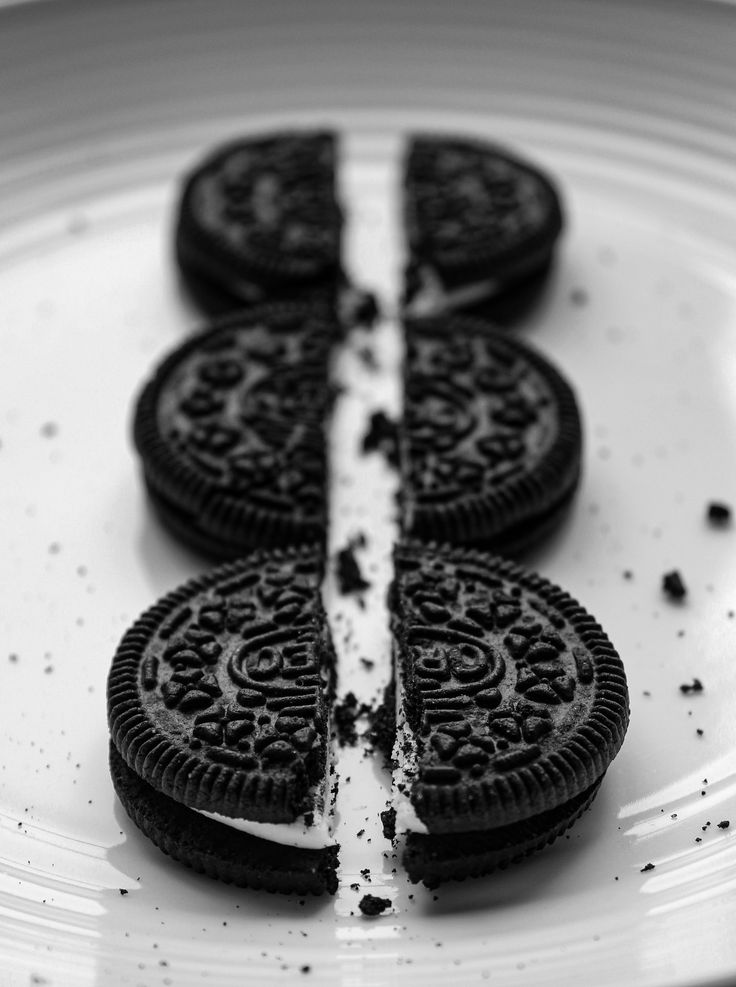 three oreo cookies sitting on top of a white plate