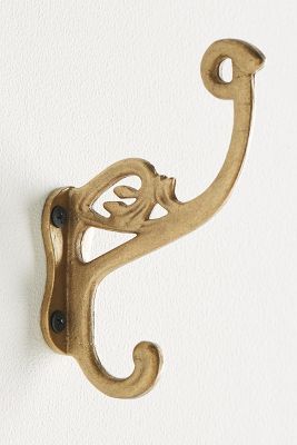 a pair of brass hooks hang on the wall