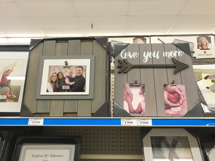 some pictures and frames are on the shelves in a store with other items for sale