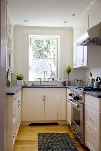 a kitchen with white cabinets and an open window above the sink is seen in this image