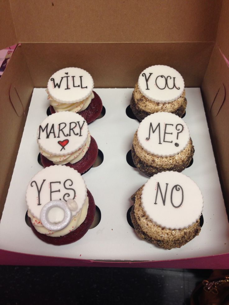 a box filled with cookies that say will you marry me? and yes, no