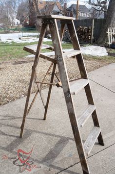 a wooden ladder sitting on top of a sidewalk