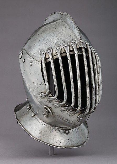 an antique silver helmet with metal rivets on the front and sides, possibly in armor