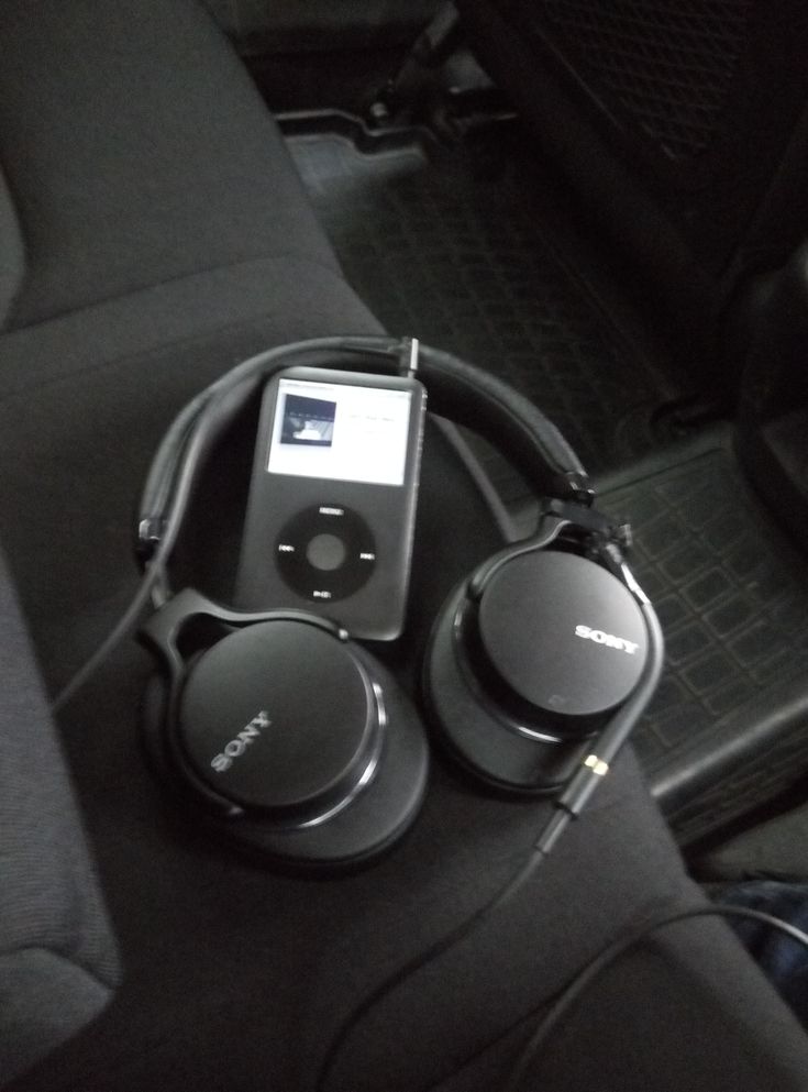 an ipod and headphones sitting in the back seat of a car