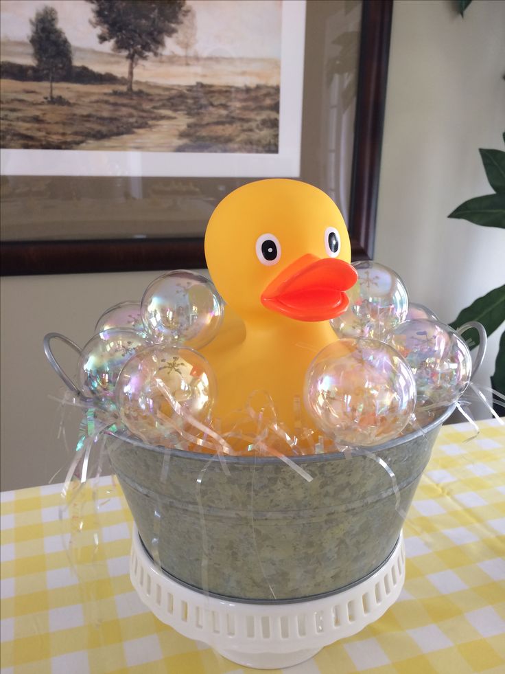 a rubber ducky sitting in a bucket filled with soap bubbles