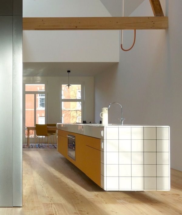 an open kitchen and dining room with wood floors, white walls and ceiling beams is shown