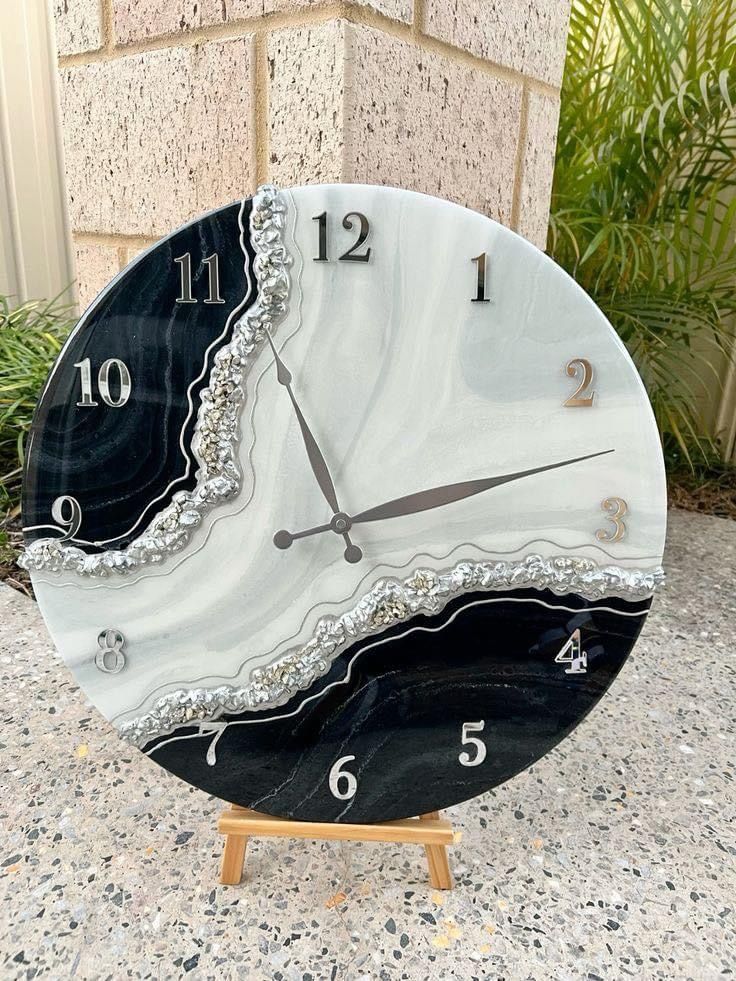 a black and white clock sitting on top of a table