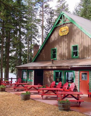 there is a small building with picnic tables in front of it and trees surrounding the building