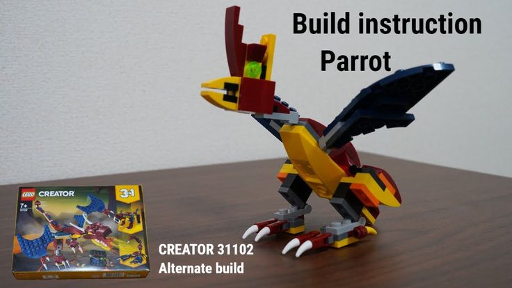 a lego bird is sitting on a table next to an instruction manual for how to build it