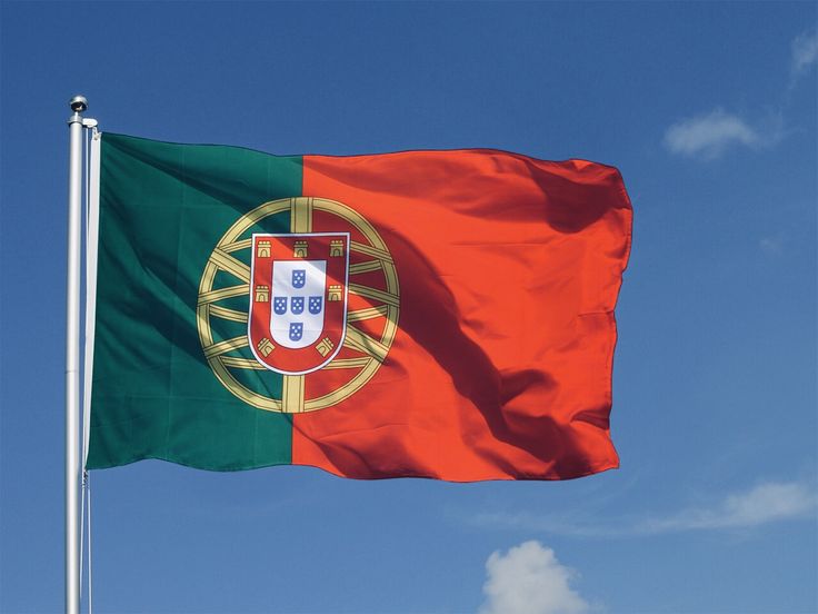 the portugal flag is flying high in the blue sky