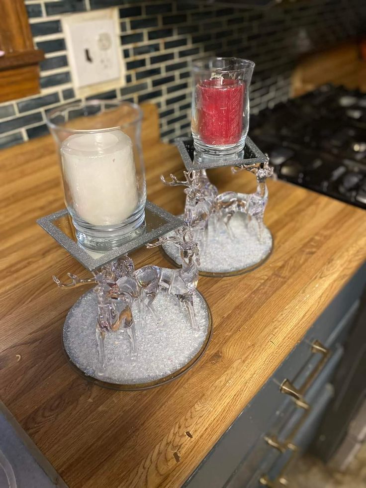 two candle holders on top of a wooden counter