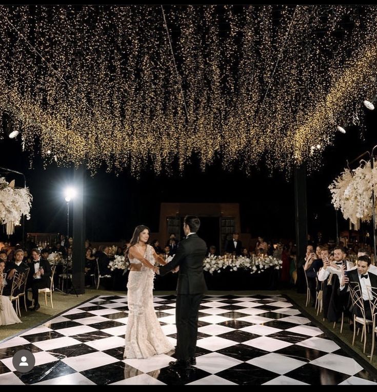 a bride and groom are dancing on the dance floor at their wedding reception in front of an audience