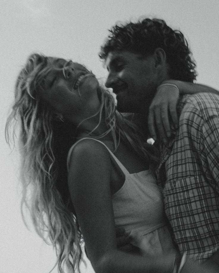 black and white photograph of a man carrying a woman on his back with the sky in the background