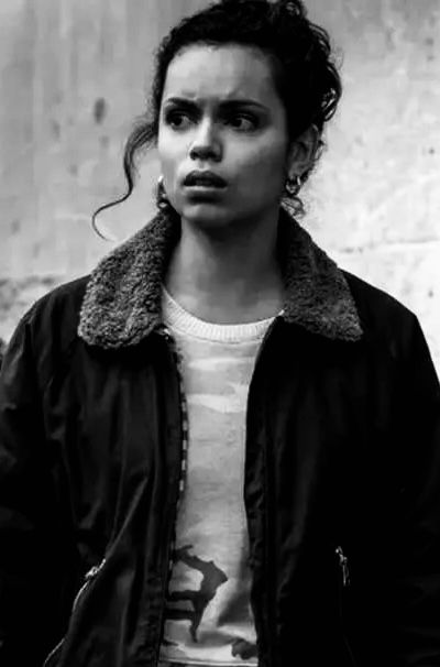 a black and white photo of a woman in a jacket looking off to the side