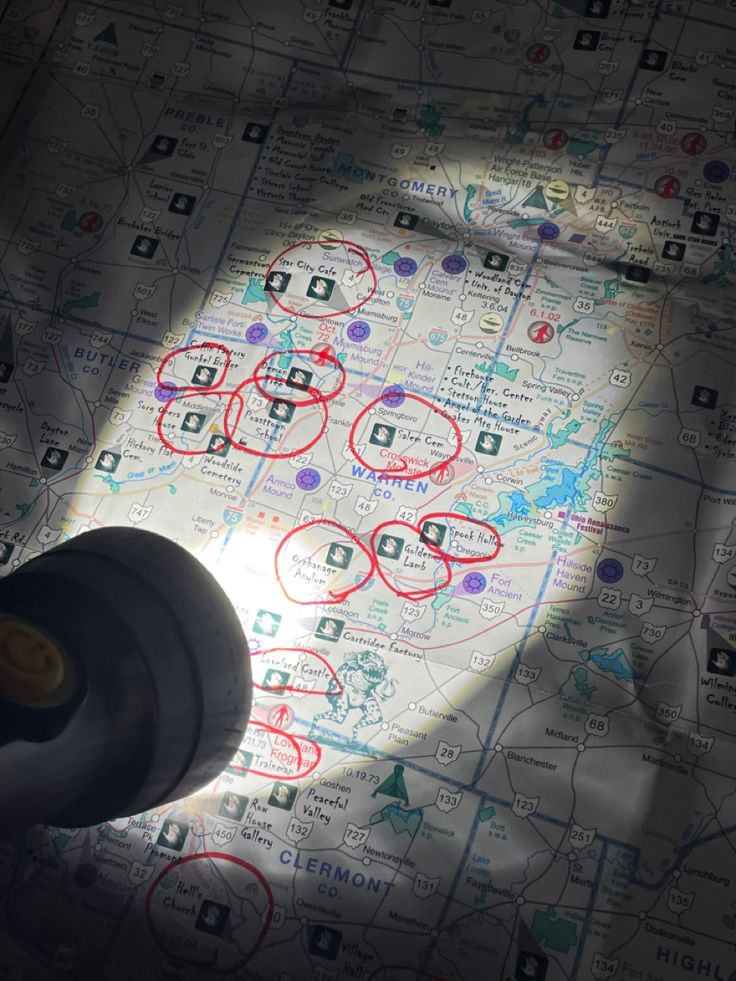 a close up of a map with red circles on it and a black object in the middle