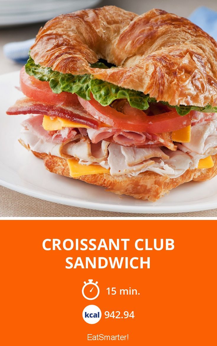 a croissant sandwich with ham is on a white plate and has an orange border around it