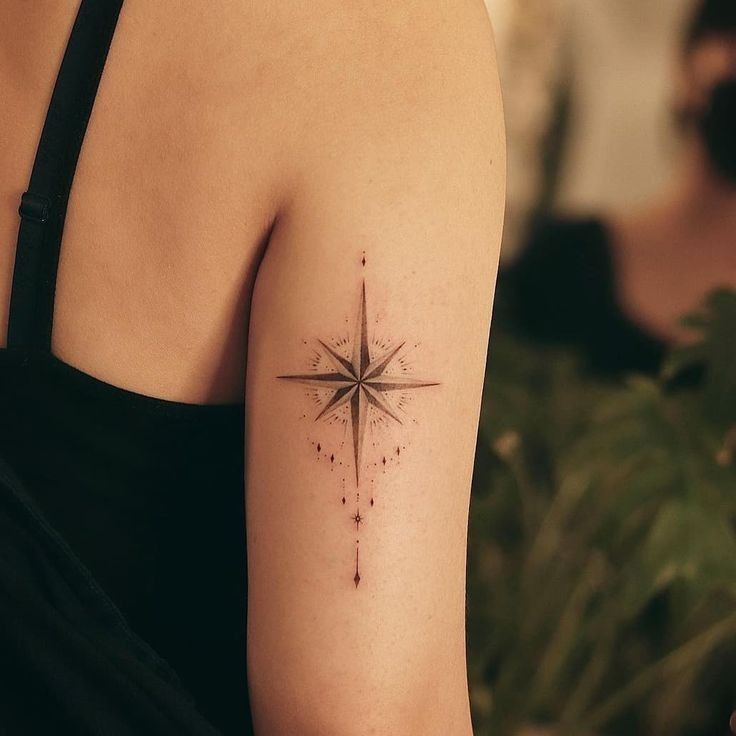 a woman's arm with a small star tattoo on it