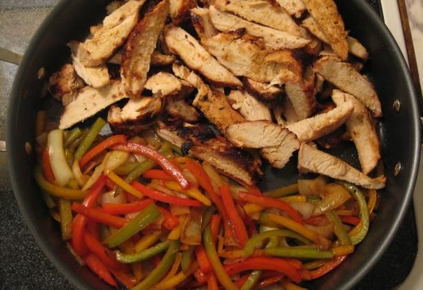 chicken and peppers are cooking in a skillet