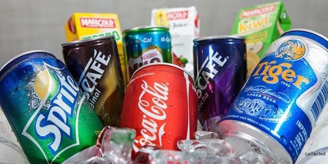 an assortment of sodas and soft drinks are in a bowl with ice cubes