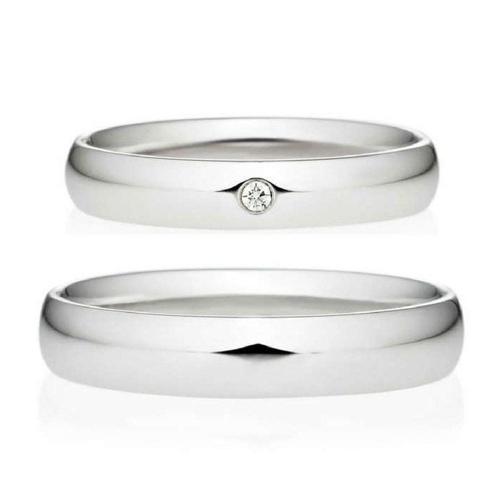 two white gold wedding bands with a diamond in the center and one on each side