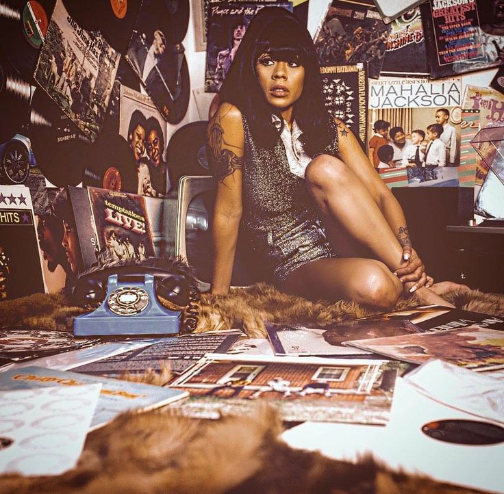 a woman sitting on the floor surrounded by magazines