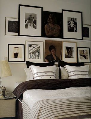 a bedroom with pictures on the wall above the bed