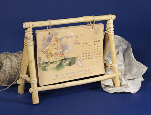 a wooden frame holding a calendar and twine of twine on a blue background