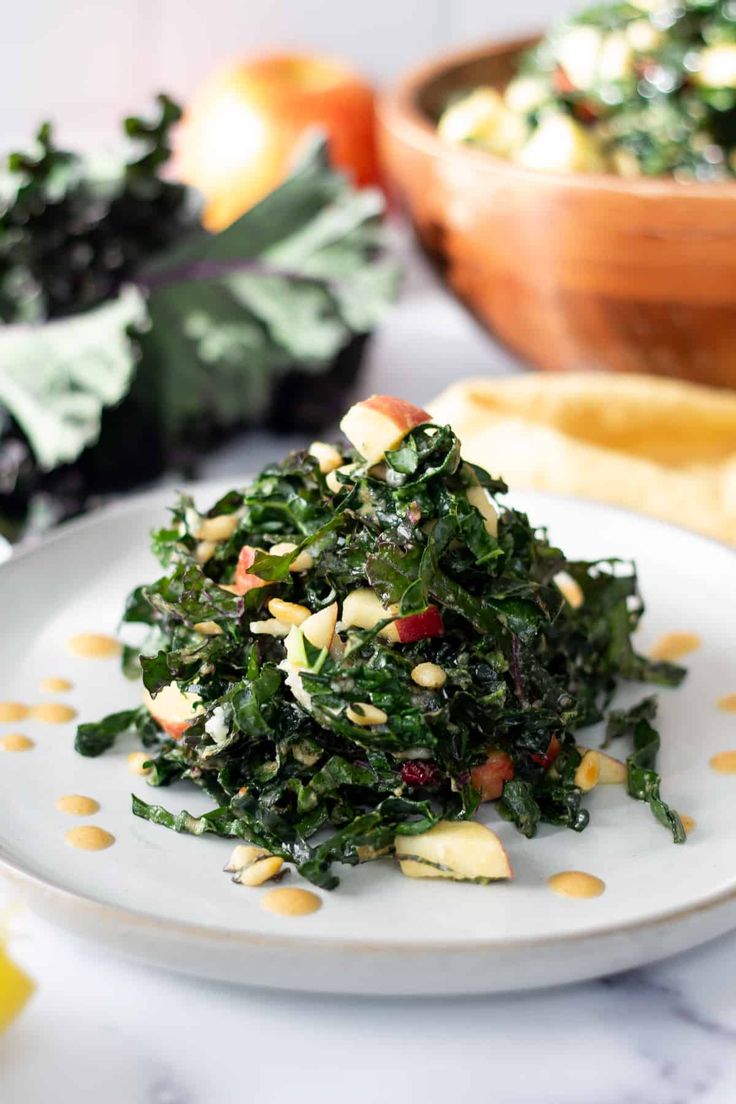 a white plate topped with greens and nuts