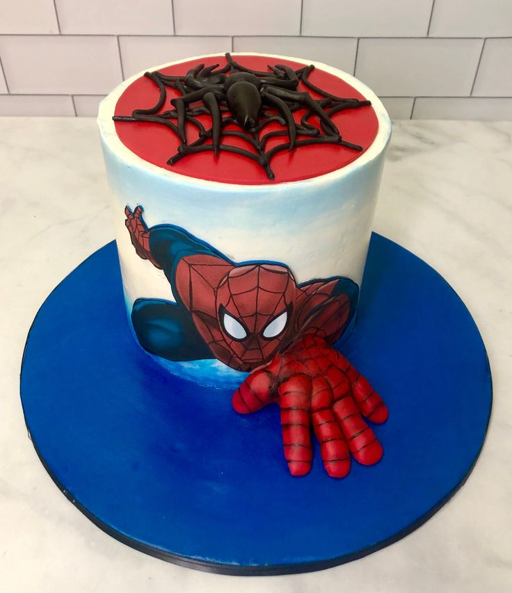 a spiderman themed cake on a blue plate