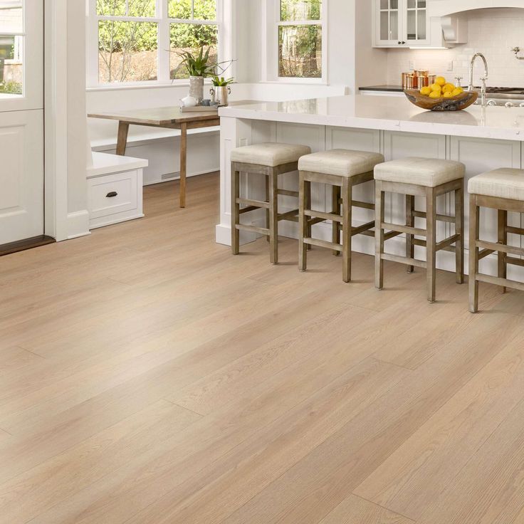 a kitchen with white cabinets and wooden floors